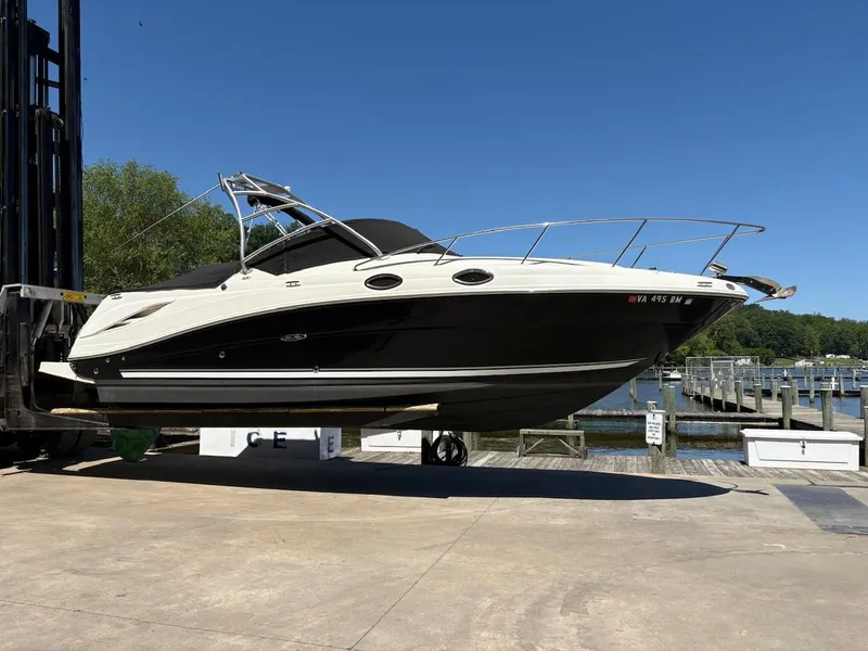 Slide: The Image of 2007 Sea Ray 270 Amberjack boat on lift at marina, clear sky background. - 0
