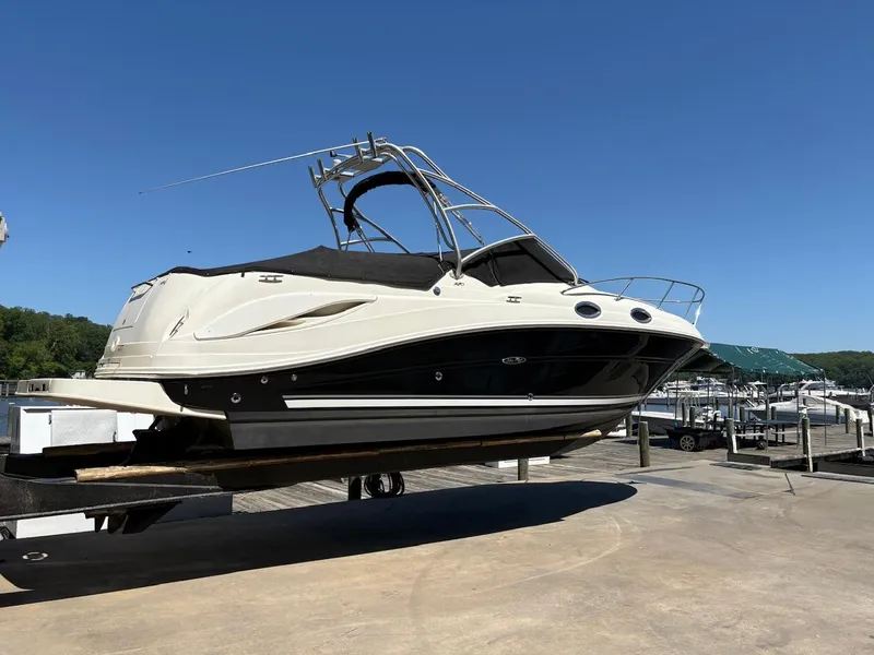 Slide: The Image of 2007 Sea Ray 270 Amberjack boat on a lift at a marina under clear blue sky. - 1