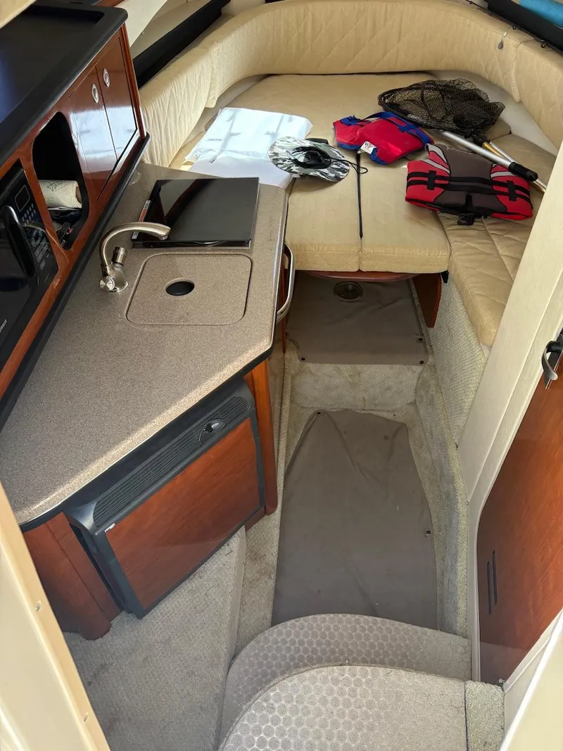 Slide: The Image of 2007 Sea Ray 270 Amberjack cabin interior with kitchenette and seating area. - 7