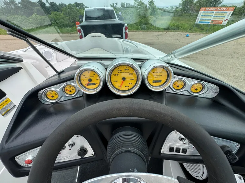 Slide: The Image of Dashboard of a 2006 MasterCraft X30 boat with yellow gauges and steering wheel. - 11
