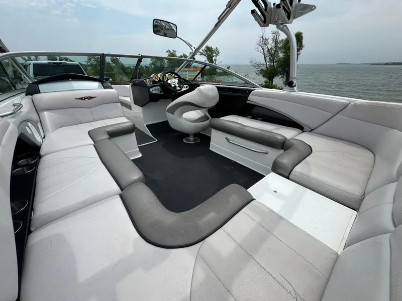 Slide: The Image of 2006 MasterCraft X30 boat interior with sleek seating and modern design on a lake. - 14