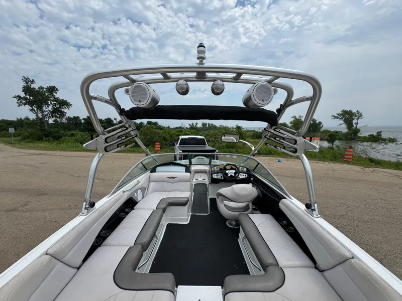 Slide: The Image of 2006 MasterCraft X30 boat interior with seating and speakers, parked near a lake. - 15