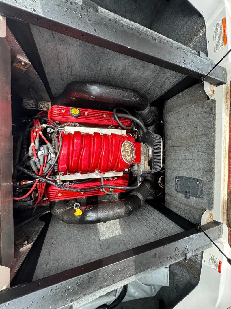 Slide: The Image of 2006 MasterCraft X30 engine compartment with red engine components and black hoses. - 18