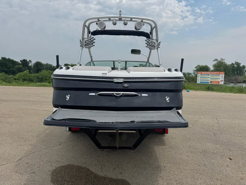 Slide: The Image of 2006 MasterCraft X30 boat, rear view, parked on pavement under cloudy sky. - 3
