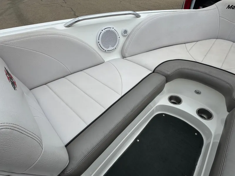 Slide: The Image of 2006 MasterCraft X30 boat interior with white and gray seating, speaker, and cup holders. - 6