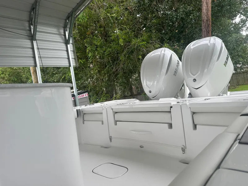 Slide: The Image of 2025 Tidewater 3100 Carolina Bay boat with dual engines, parked under a canopy. - 12