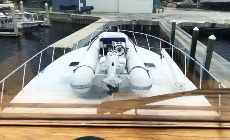 Slide: The Image of 1993 Palmer Johnson Sportfish yacht docked, featuring a spacious deck and inflatable dinghy. - 15