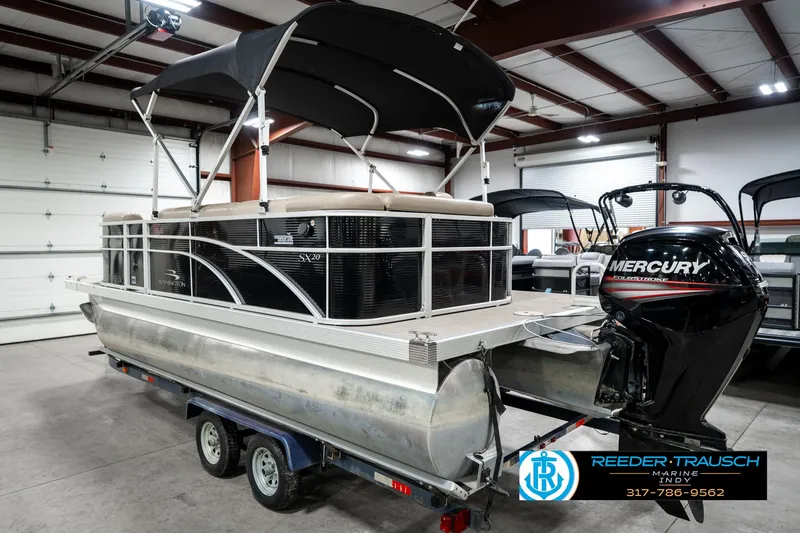 Slide: The Image of 2016 Bennington 20 SLMX pontoon boat with Mercury outboard motor in a showroom. - 10