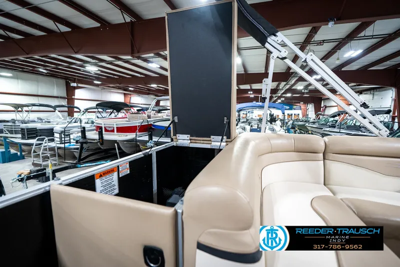 Slide: The Image of 2016 Bennington 20 SLMX pontoon boat interior in showroom with beige seating. - 29