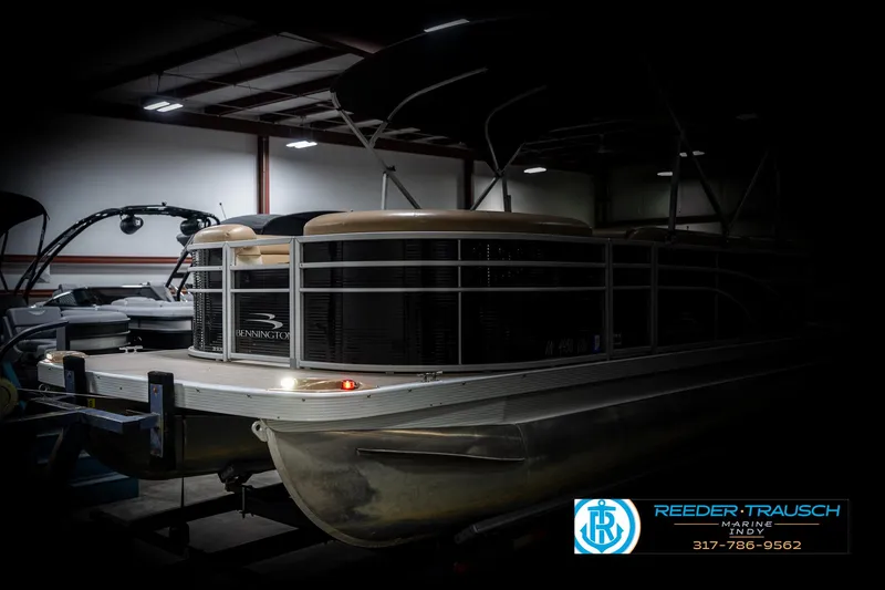 Slide: The Image of 2016 Bennington 20 SLMX pontoon boat in a dimly lit indoor storage facility. - 4