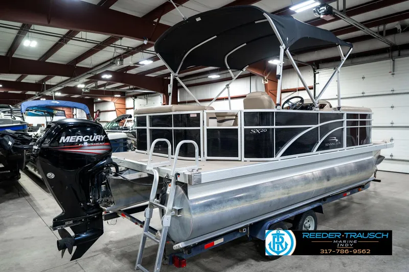 Slide: The Image of 2016 Bennington 20 SLMX pontoon boat with Mercury outboard motor in indoor showroom. - 8