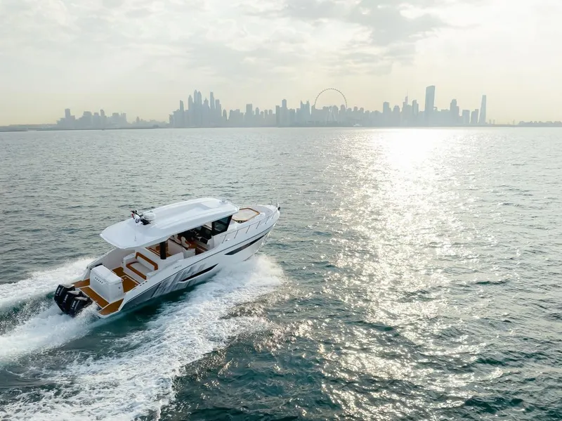 Slide: The Image of 2025 Oryx 37 FX yacht cruising on open water with city skyline in background. - 7
