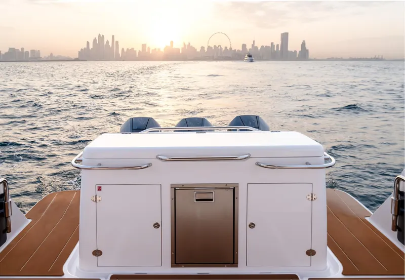 Slide: The Image of Oryx 37 FX boat, 2025 model, cruising towards city skyline at sunset. - 8