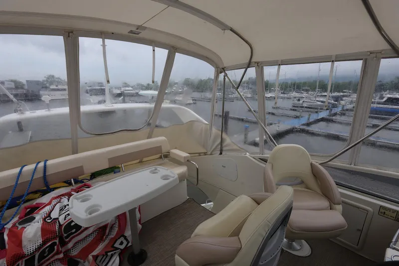 Slide: The Image of Interior view of 2012 Carver 38 Super Sport yacht at marina, featuring seating and helm. - 43