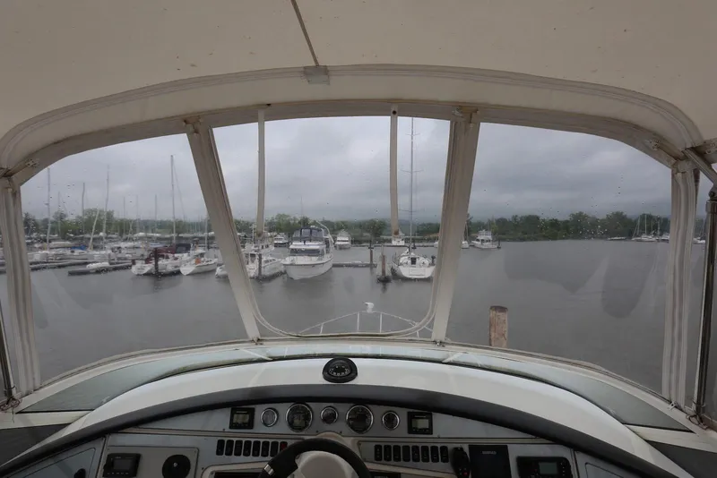 Slide: The Image of 2012 Carver 38 Super Sport yacht cockpit view overlooking marina with docked boats. - 33
