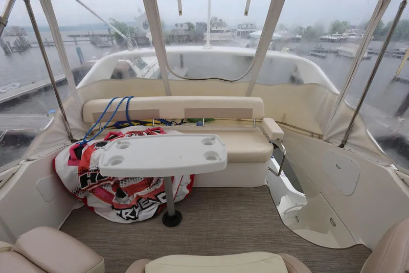 Slide: The Image of Flybridge of 2012 Carver 38 Super Sport with seating and table, overlooking marina. - 40