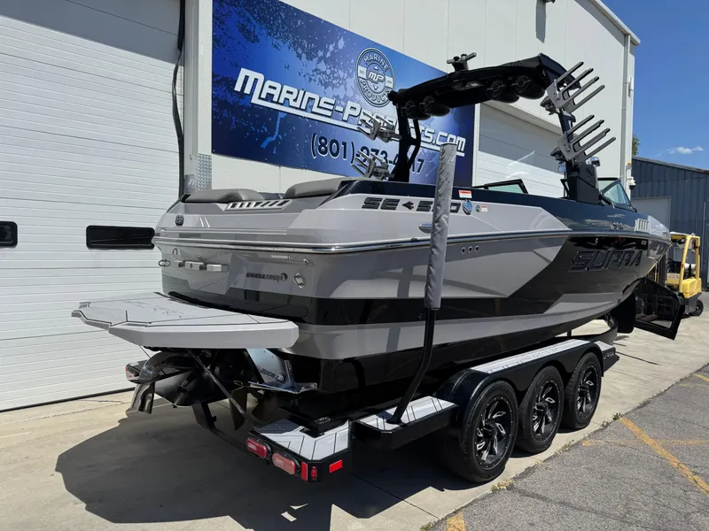 Slide: The Image of 2020 Supra SE550 boat on trailer outside Marine Parts store. - 3