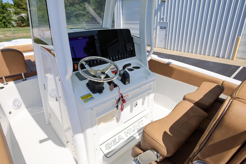 Slide: The Image of 2019 Sea Hunt Ultra 255 SE boat console with steering wheel and navigation equipment. - 11
