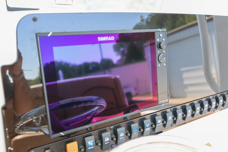 Slide: The Image of Simrad display on 2019 Sea Hunt Ultra 255 SE boat dashboard with control switches. - 12