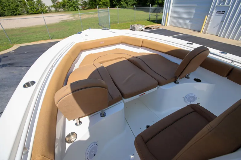 Slide: The Image of 2019 Sea Hunt Ultra 255 SE boat with brown cushioned seating in a marina setting. - 18