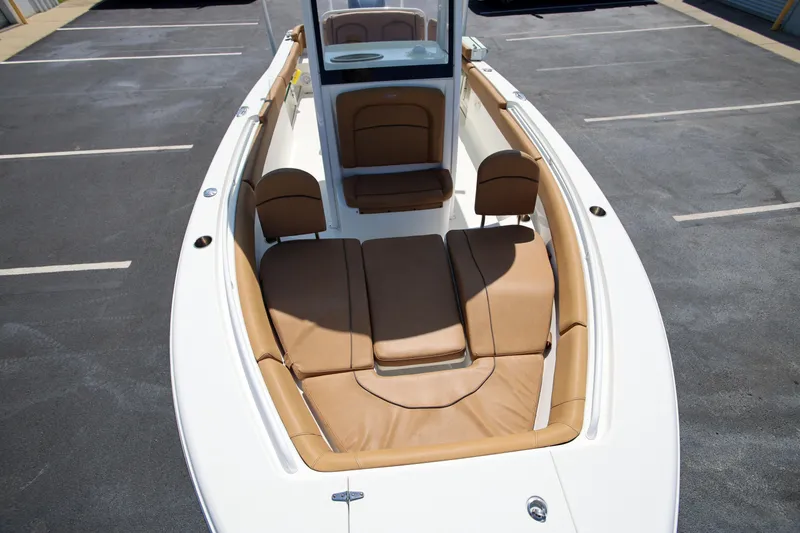 Slide: The Image of 2019 Sea Hunt Ultra 255 SE boat with tan seating in a parking lot. - 19