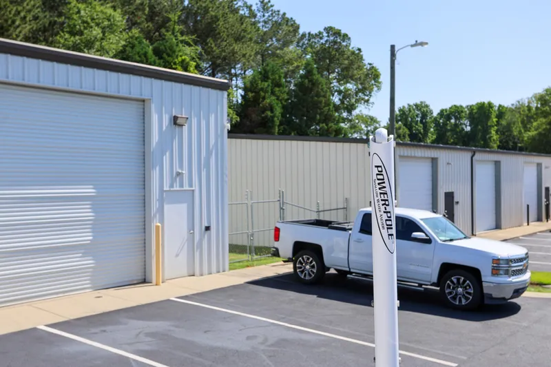 Slide: The Image of White truck parked near industrial storage units and Power-Pole equipment. - 22