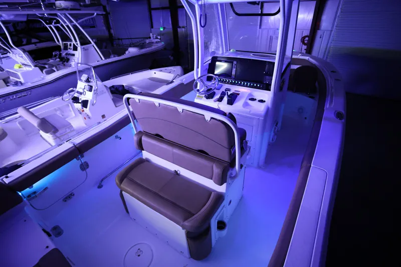 Slide: The Image of 2019 Sea Hunt Ultra 255 SE boat interior with illuminated dashboard and seating. - 26