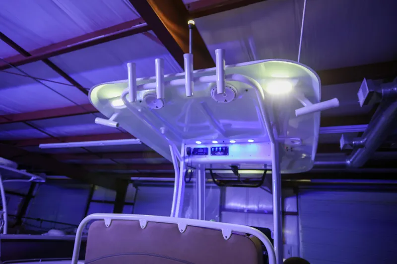 Slide: The Image of 2019 Sea Hunt Ultra 255 SE boat with illuminated T-top in a warehouse setting. - 29