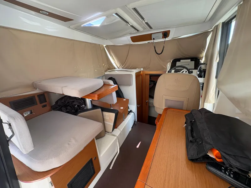 Slide: The Image of Interior of 2018 Jeanneau Merry Fisher 855 boat, featuring seating and helm area. - 15