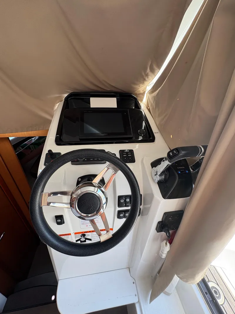Slide: The Image of 2018 Jeanneau Merry Fisher 855 helm with steering wheel and navigation controls. - 17