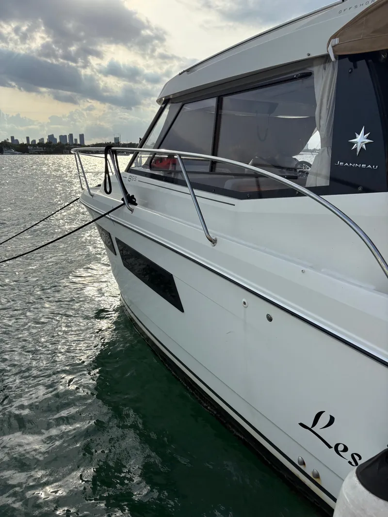 Slide: The Image of 2018 Jeanneau Merry Fisher 855 boat on water, city skyline in background. - 31