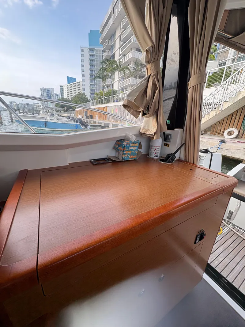 Slide: The Image of Interior view of 2018 Jeanneau Merry Fisher 855 with wooden cabinetry and marina backdrop. - 36