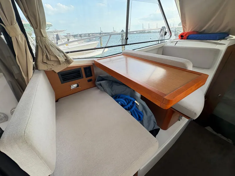 Slide: The Image of Interior of 2018 Jeanneau Merry Fisher 855 with seating and table, overlooking marina. - 37