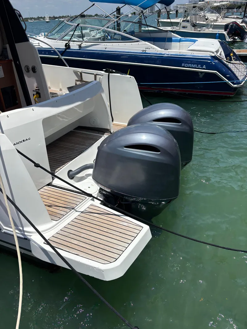 Slide: The Image of 2018 Jeanneau Merry Fisher 855 with dual outboard motors docked in marina. - 4