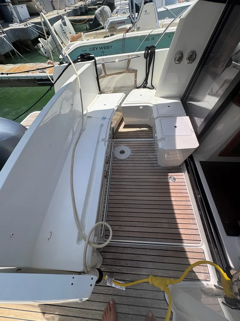 Slide: The Image of 2018 Jeanneau Merry Fisher 855 boat deck with seating and wooden flooring. - 5