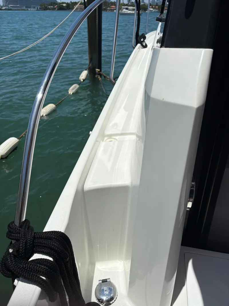 Slide: The Image of 2018 Jeanneau Merry Fisher 855 boat deck with railing, docked on calm water. - 9