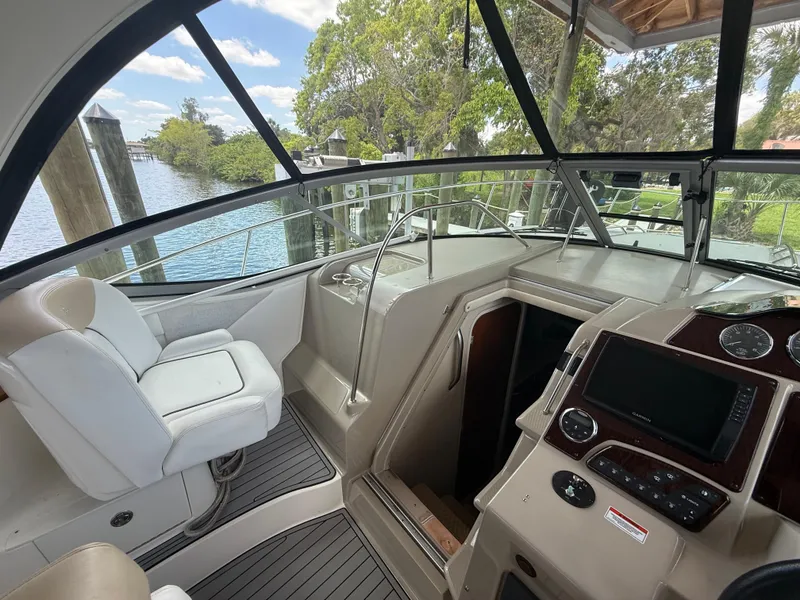 Slide: The Image of 2008 Sea Ray 330 Sundancer cockpit with helm, white seating, and water view. - 13