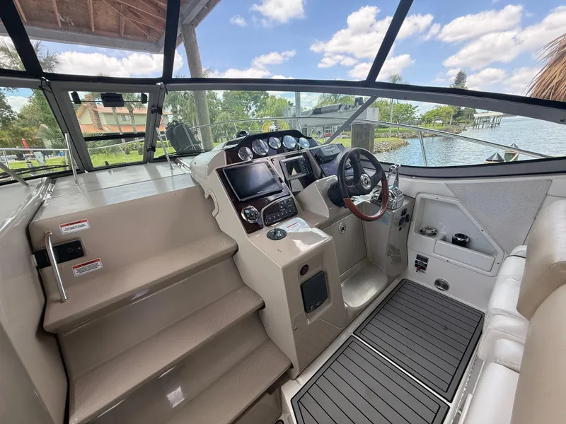 Slide: The Image of 2008 Sea Ray 330 Sundancer helm with modern controls and scenic marina view. - 14