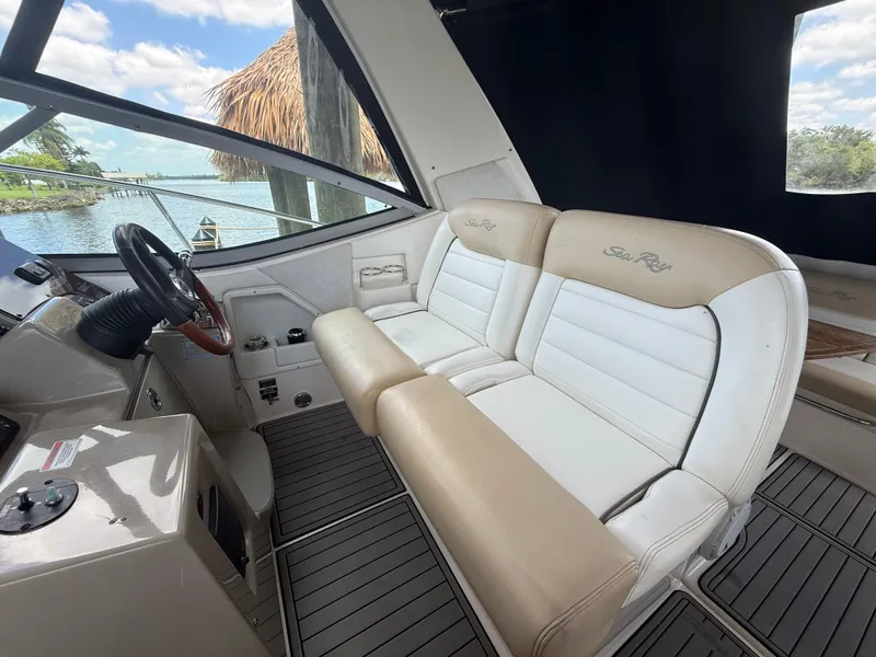 Slide: The Image of 2008 Sea Ray 330 Sundancer cockpit with beige and white seating, overlooking serene waters. - 17