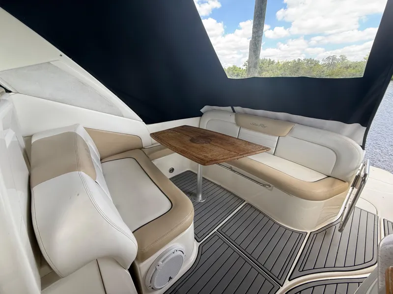 Slide: The Image of 2008 Sea Ray 330 Sundancer interior with cushioned seating and wooden table. - 18