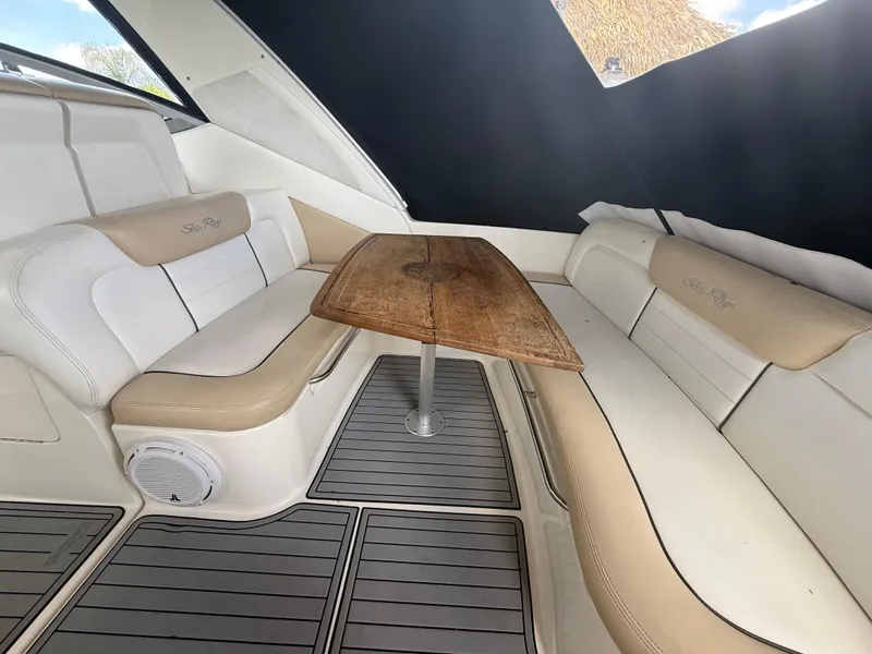 Slide: The Image of 2008 Sea Ray 330 Sundancer interior with cushioned seating and wooden table. - 19