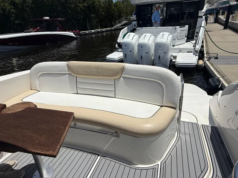 Slide: The Image of 2008 Sea Ray 330 Sundancer boat with cushioned seating and wooden table on deck. - 20