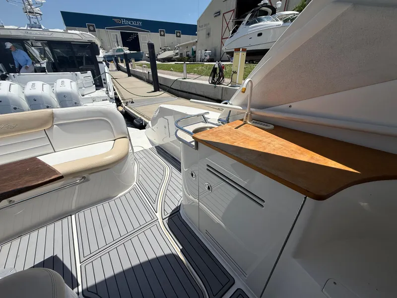 Slide: The Image of 2008 Sea Ray 330 Sundancer boat interior with seating and kitchenette, docked at a marina. - 21