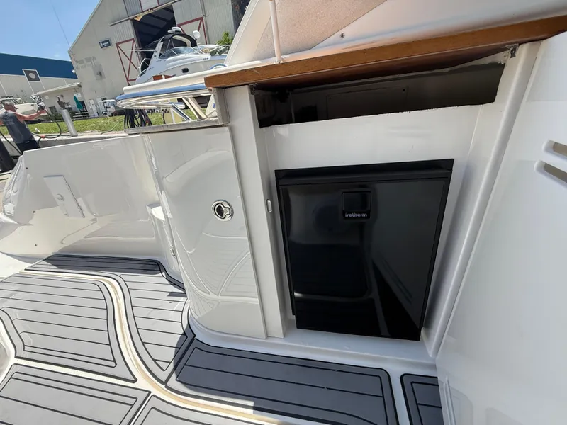 Slide: The Image of 2008 Sea Ray 330 Sundancer boat interior with mini fridge and sleek flooring. - 22