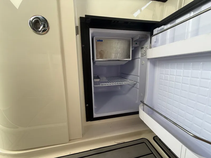 Slide: The Image of Open mini fridge on 2008 Sea Ray 330 Sundancer boat, showing interior shelves. - 23