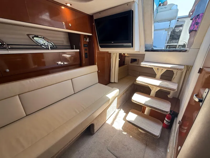 Slide: The Image of Interior of 2008 Sea Ray 330 Sundancer with beige seating, TV, and stairs. - 26