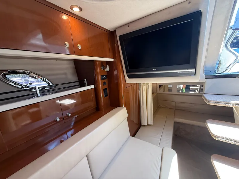 Slide: The Image of Interior of 2008 Sea Ray 330 Sundancer with TV, seating, and wooden cabinetry. - 27