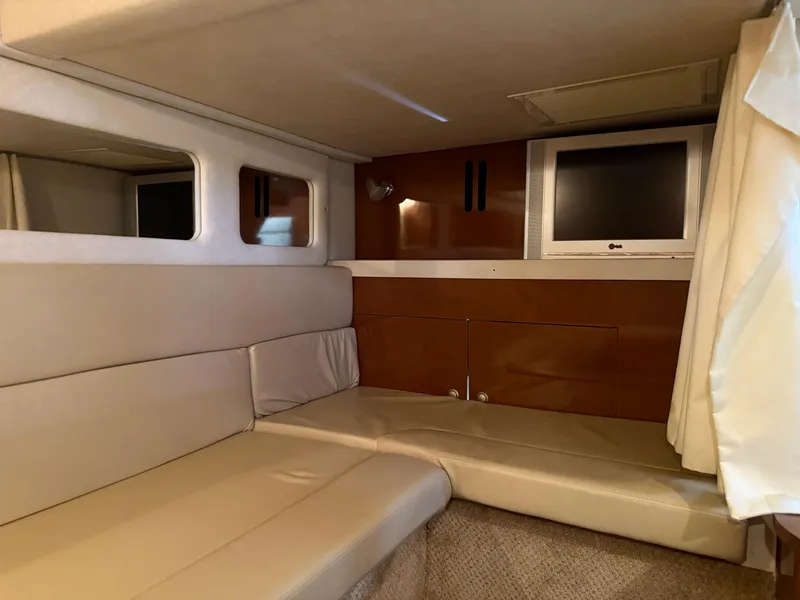 Slide: The Image of Interior of 2008 Sea Ray 330 Sundancer with beige seating and a mounted TV. - 35