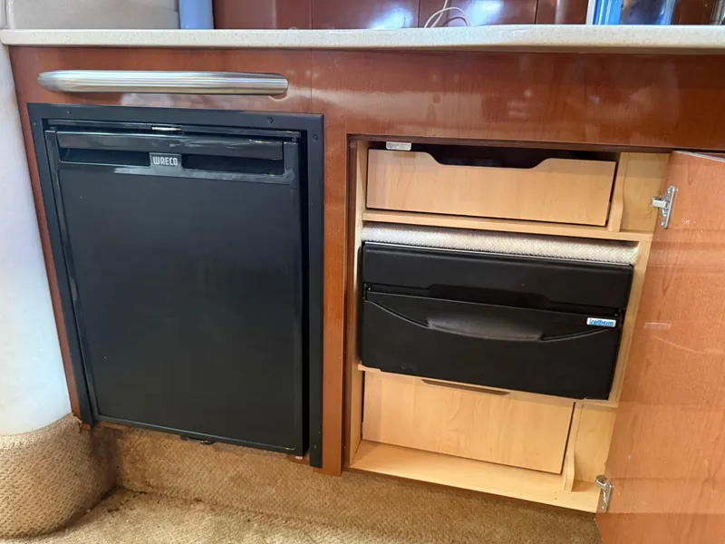 Slide: The Image of 2008 Sea Ray 330 Sundancer interior with fridge and storage cabinets. - 38