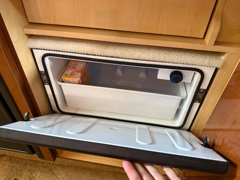 Slide: The Image of Mini fridge inside 2008 Sea Ray 330 Sundancer boat, open with visible contents. - 39